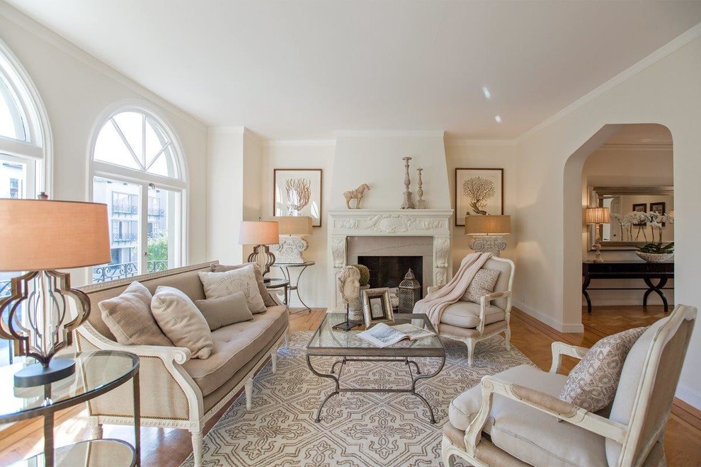 Example of a mid-sized classic formal and enclosed light wood floor and brown floor living room design in San Francisco with white walls, a standard fireplace, a plaster fireplace and no tv