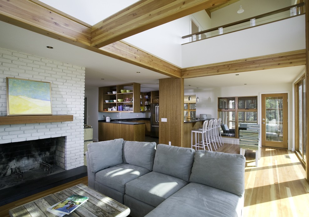 Example of a beach style open concept living room design in Boston with a standard fireplace and a brick fireplace
