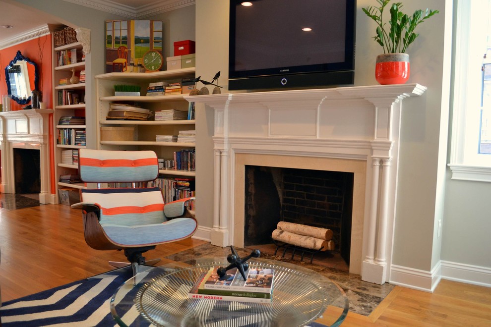Cette photo montre un grand salon moderne ouvert avec un sol en bois brun, une cheminée standard, un mur vert, un manteau de cheminée en bois et un téléviseur fixé au mur.