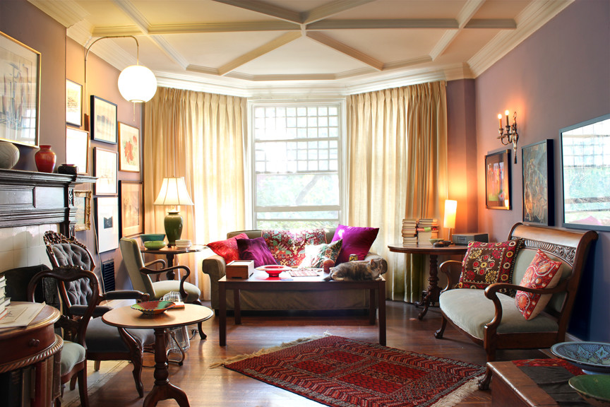 Cette photo montre un salon éclectique de taille moyenne et fermé avec une salle de réception, un mur violet, parquet foncé, une cheminée standard, un manteau de cheminée en carrelage, aucun téléviseur et un sol marron.