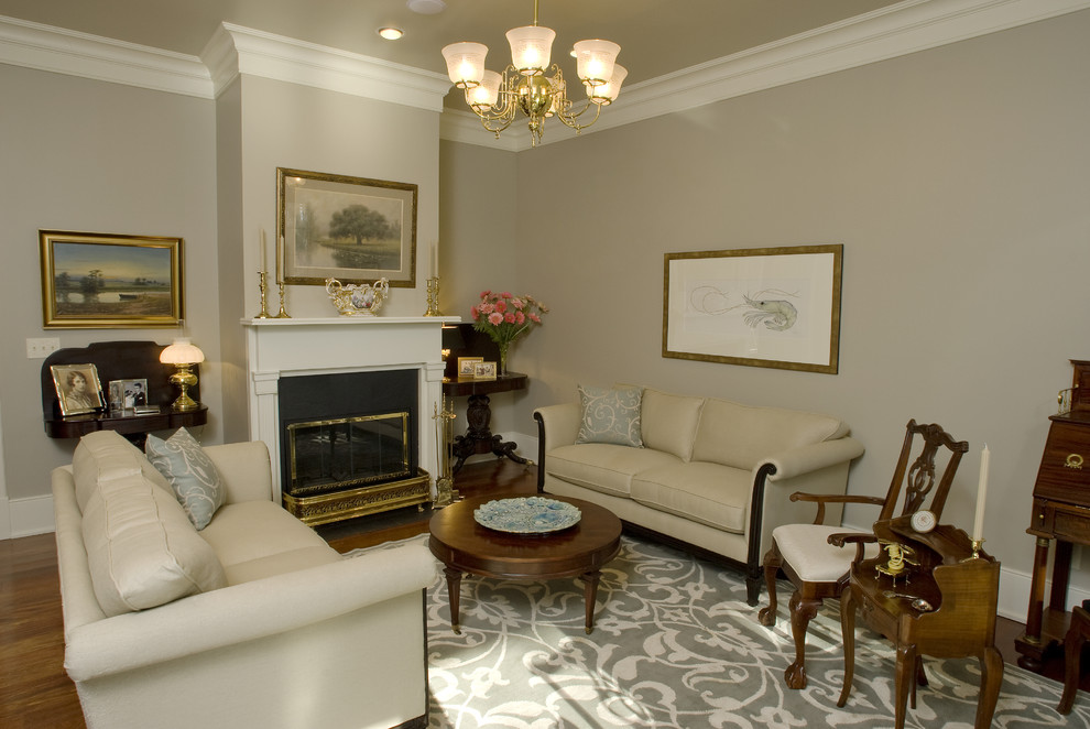 Fernseherloses, Abgetrenntes Klassisches Wohnzimmer mit grauer Wandfarbe, braunem Holzboden, Kamin und Kaminumrandung aus Holz in New Orleans