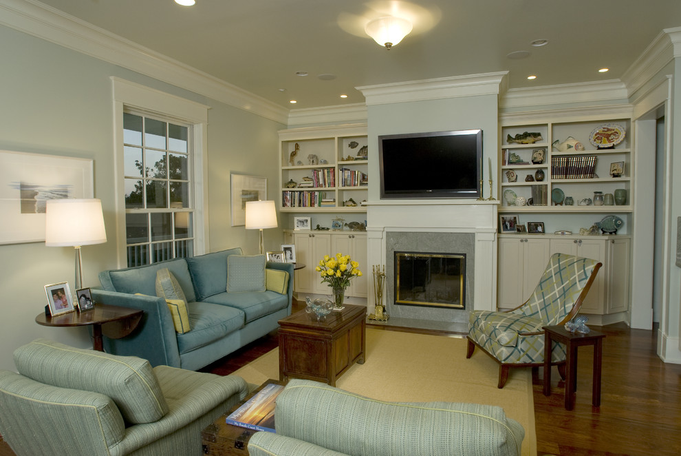 Свежая идея для дизайна: изолированная гостиная комната среднего размера в классическом стиле с синими стенами, паркетным полом среднего тона, стандартным камином, фасадом камина из камня и телевизором на стене - отличное фото интерьера