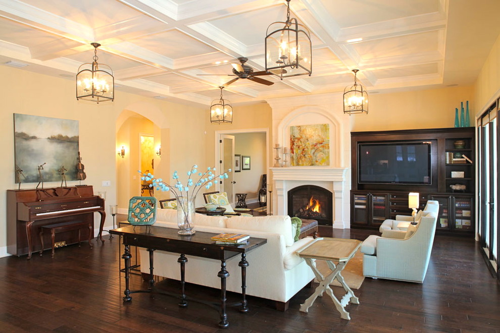 Tuscan living room photo in Tampa with beige walls, a standard fireplace and a media wall