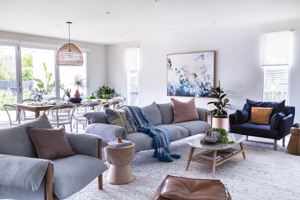 Offenes Modernes Wohnzimmer mit weißer Wandfarbe und braunem Holzboden in Melbourne