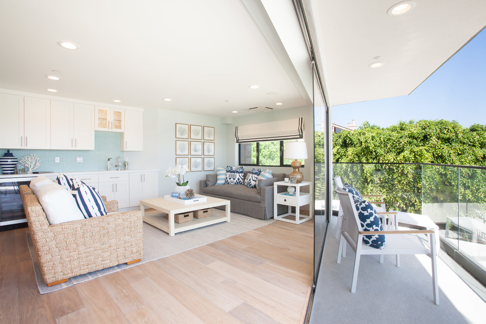 На фото: открытая гостиная комната в морском стиле с серыми стенами и паркетным полом среднего тона с