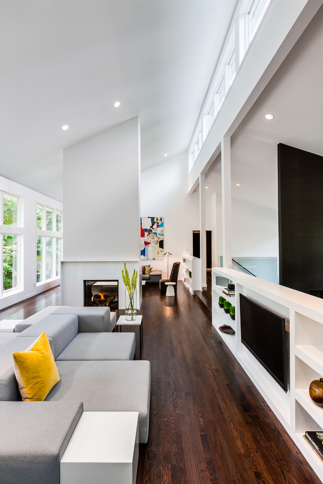 На фото: гостиная комната в современном стиле с двусторонним камином с
