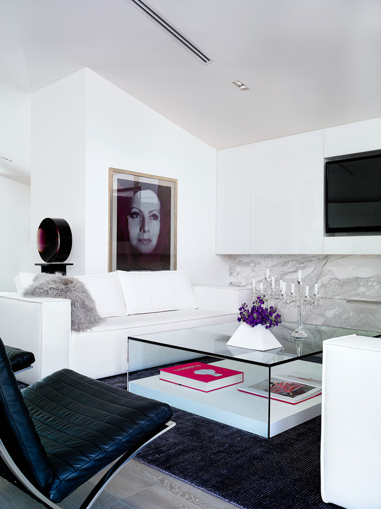 На фото: гостиная комната в современном стиле с паркетным полом среднего тона, стандартным камином, фасадом камина из камня, белыми стенами и мультимедийным центром