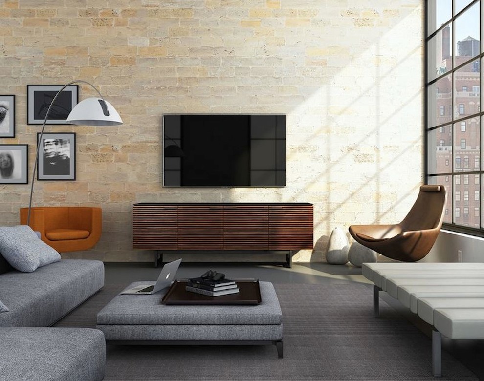 Inspiration for a medium sized contemporary living room in San Diego with beige walls, concrete flooring, no fireplace, a brick fireplace surround and a freestanding tv.