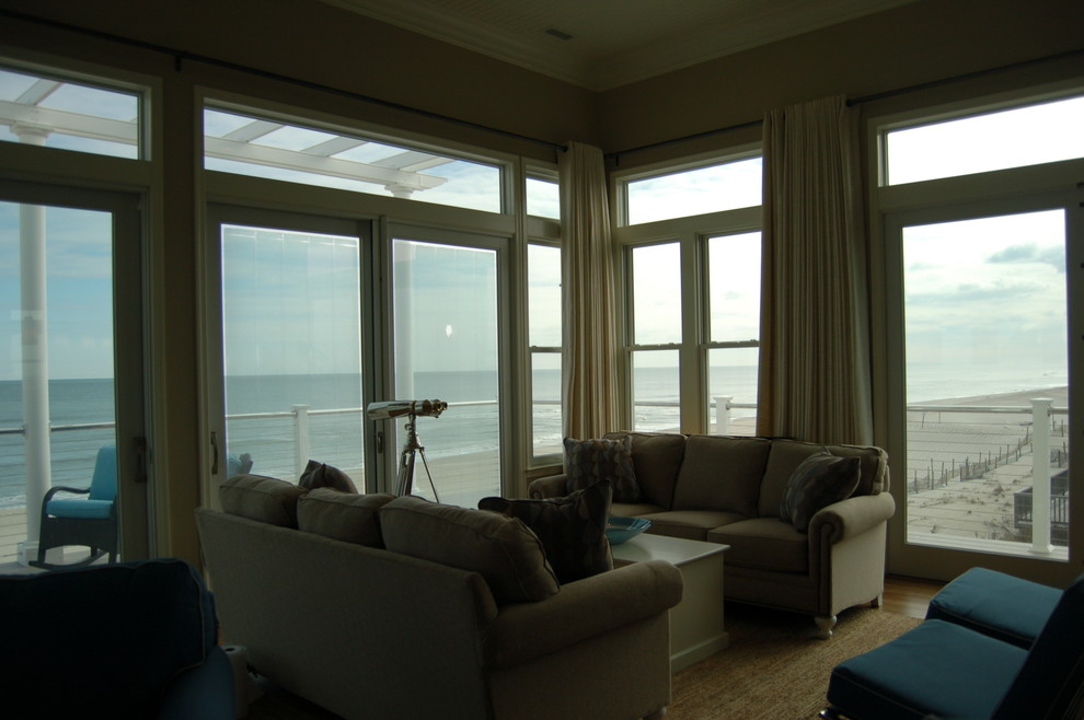 Foto di un soggiorno stile marino di medie dimensioni e aperto con pareti beige e pavimento in legno massello medio