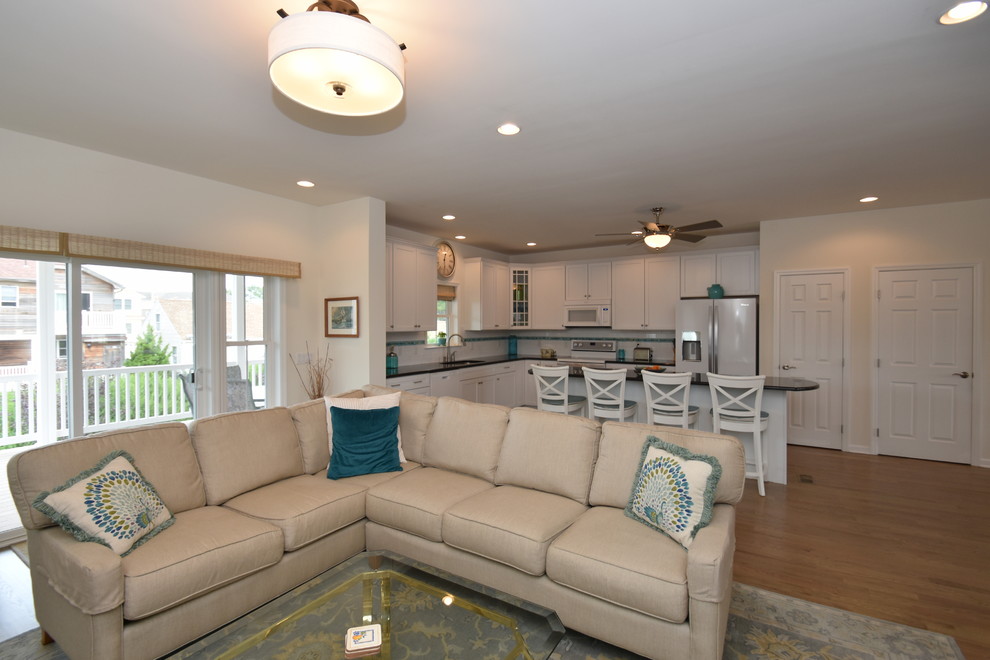 Medium sized beach style open plan living room in Other with white walls and light hardwood flooring.