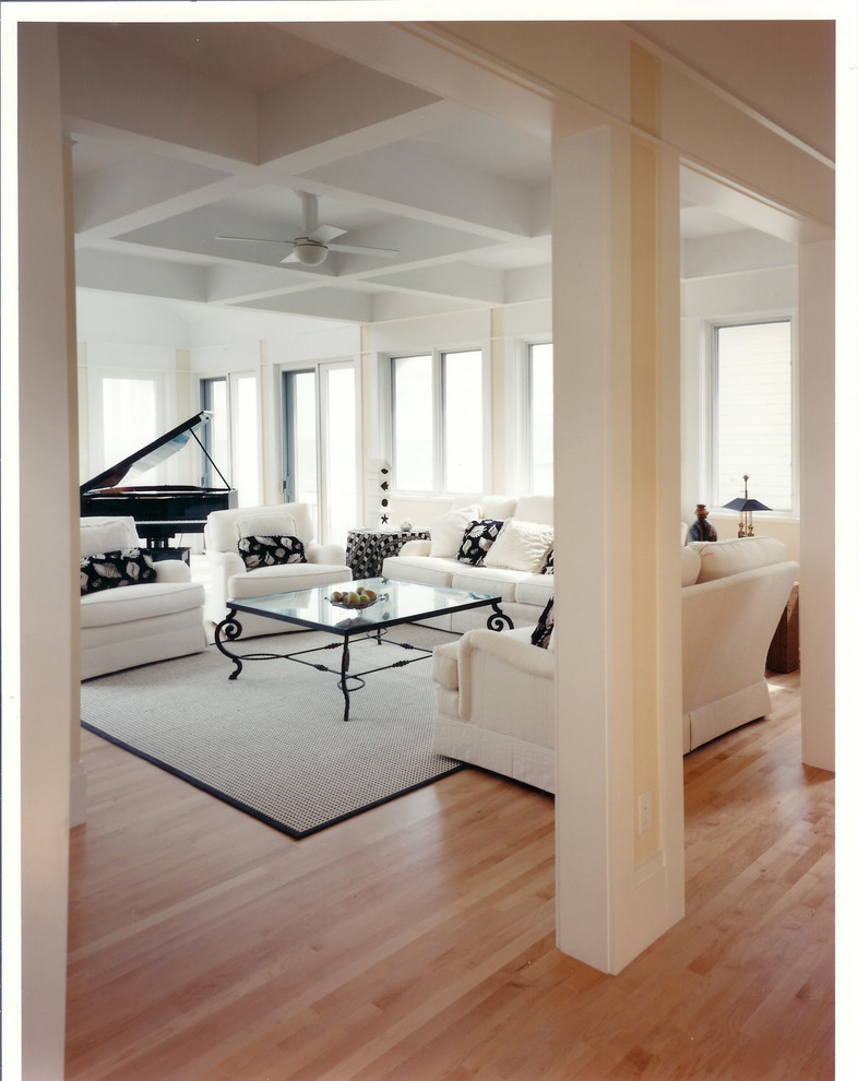 Пример оригинального дизайна: большая парадная, открытая гостиная комната в морском стиле с бежевыми стенами, светлым паркетным полом, двусторонним камином, скрытым телевизором и фасадом камина из дерева