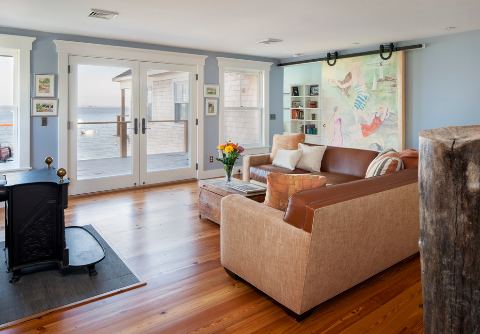 Mittelgroßes, Offenes Maritimes Wohnzimmer mit blauer Wandfarbe, braunem Holzboden und Kaminofen in Boston
