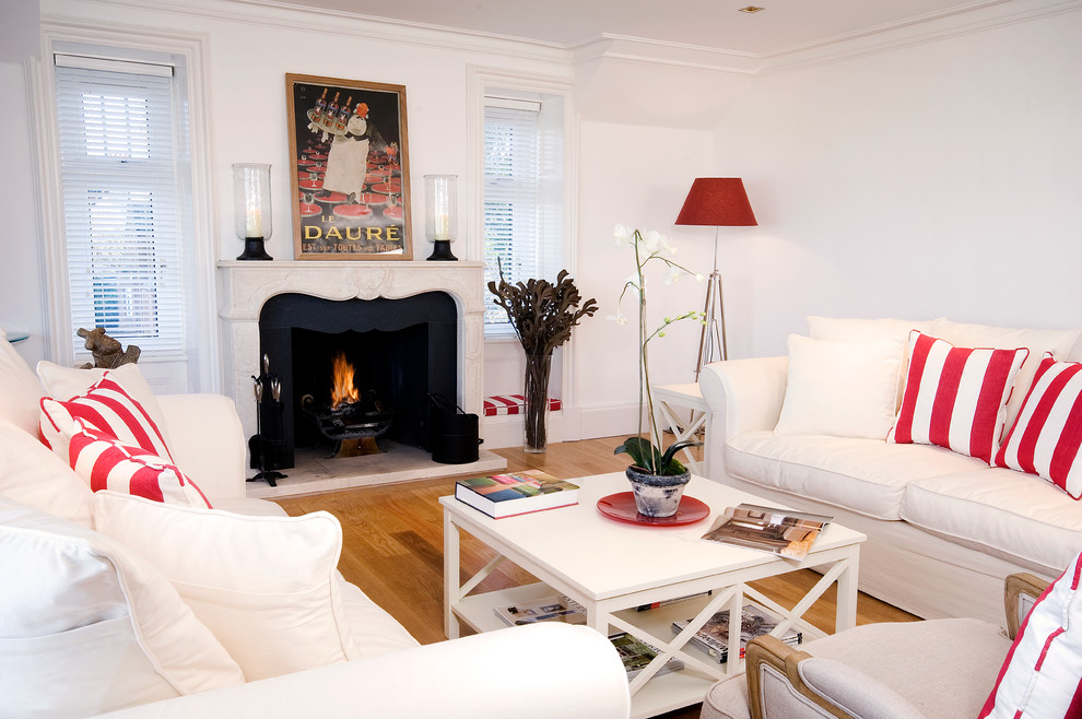 Esempio di un soggiorno chic con pareti bianche, pavimento in legno massello medio e camino classico