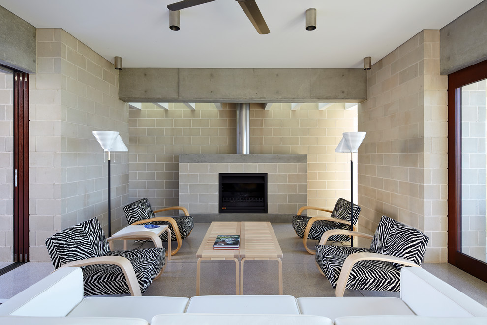 Cette photo montre un salon tendance ouvert avec une salle de réception, une cheminée standard, un mur gris, un manteau de cheminée en béton et un sol blanc.