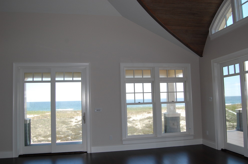 Exemple d'un grand salon bord de mer ouvert avec une salle de réception, un mur beige et parquet foncé.