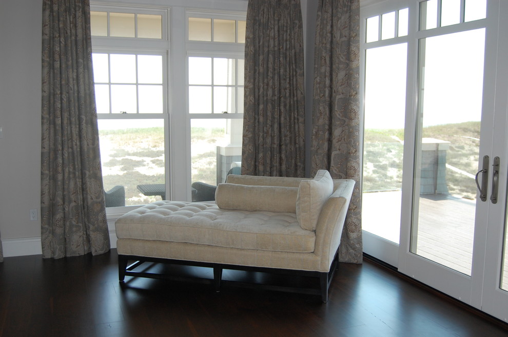 Modelo de salón para visitas abierto costero grande con paredes grises y suelo de madera oscura