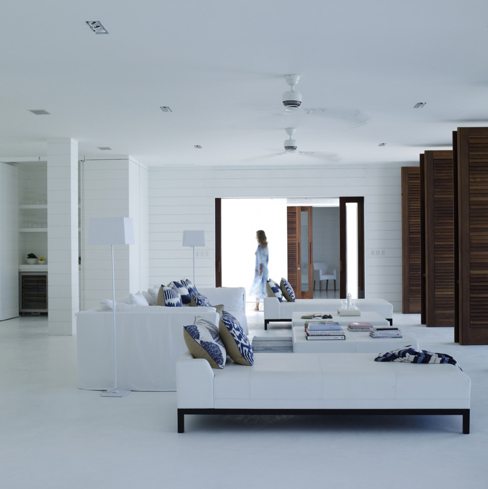 Geräumiges, Repräsentatives, Fernseherloses, Offenes Wohnzimmer mit weißer Wandfarbe und Betonboden in Sonstige