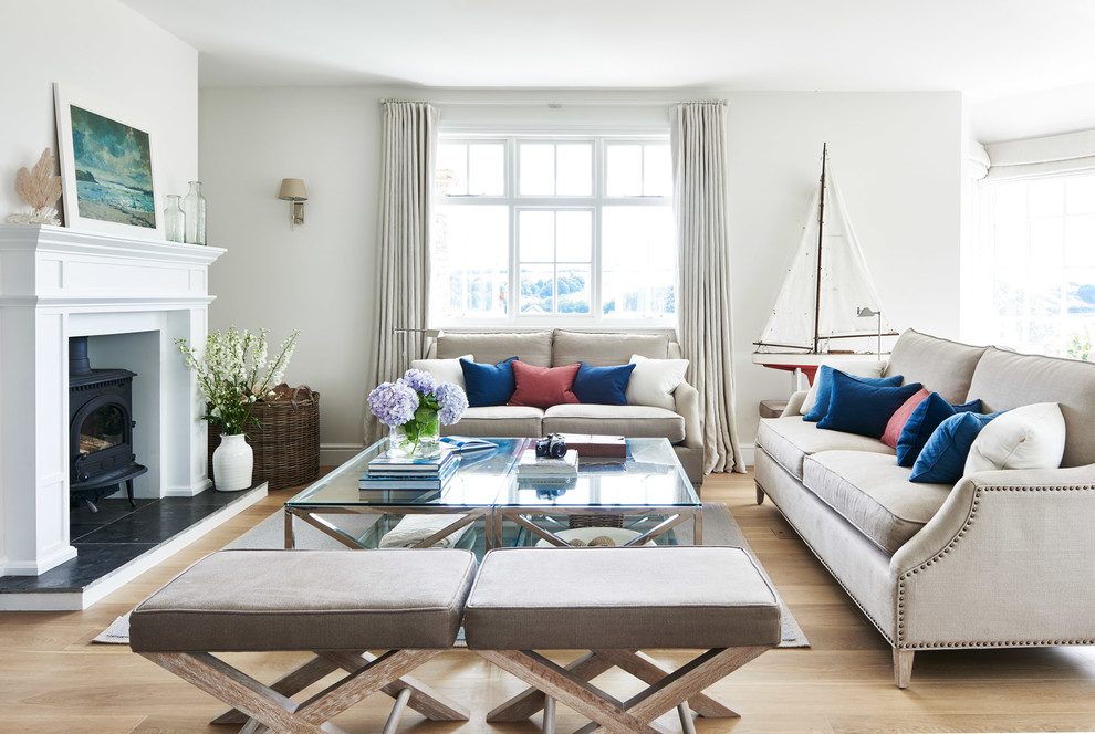 Repräsentatives, Fernseherloses Maritimes Wohnzimmer mit hellem Holzboden, Kaminofen, beigem Boden und weißer Wandfarbe in Wiltshire