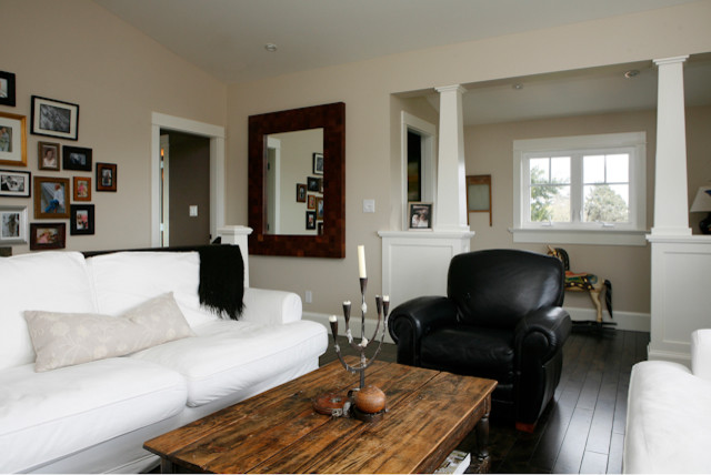 Cette image montre un grand salon craftsman ouvert avec une salle de réception, un mur beige, parquet foncé et un téléviseur dissimulé.