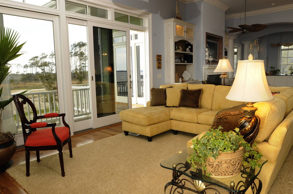 Пример оригинального дизайна: открытая гостиная комната среднего размера в морском стиле с синими стенами, паркетным полом среднего тона, стандартным камином, фасадом камина из дерева и телевизором на стене