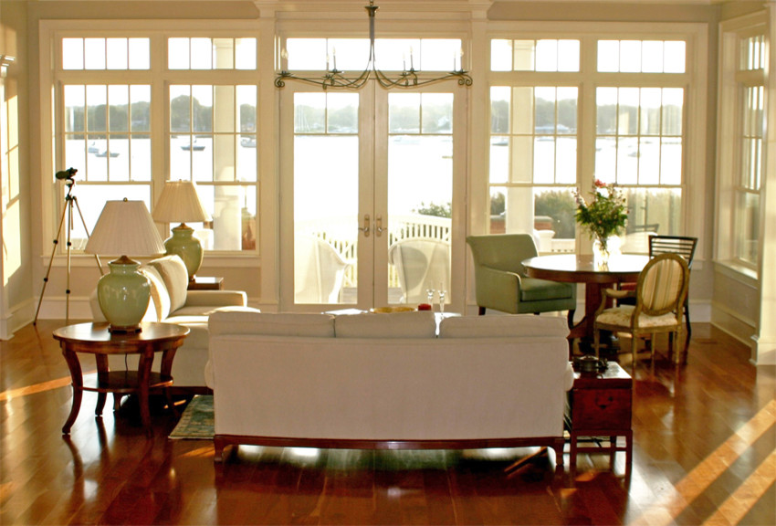 Großes, Offenes Maritimes Wohnzimmer mit weißer Wandfarbe, braunem Holzboden, Kamin und Kaminumrandung aus Stein in Bridgeport