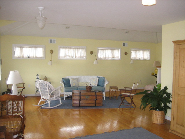 Foto de salón abierto costero con suelo de madera clara