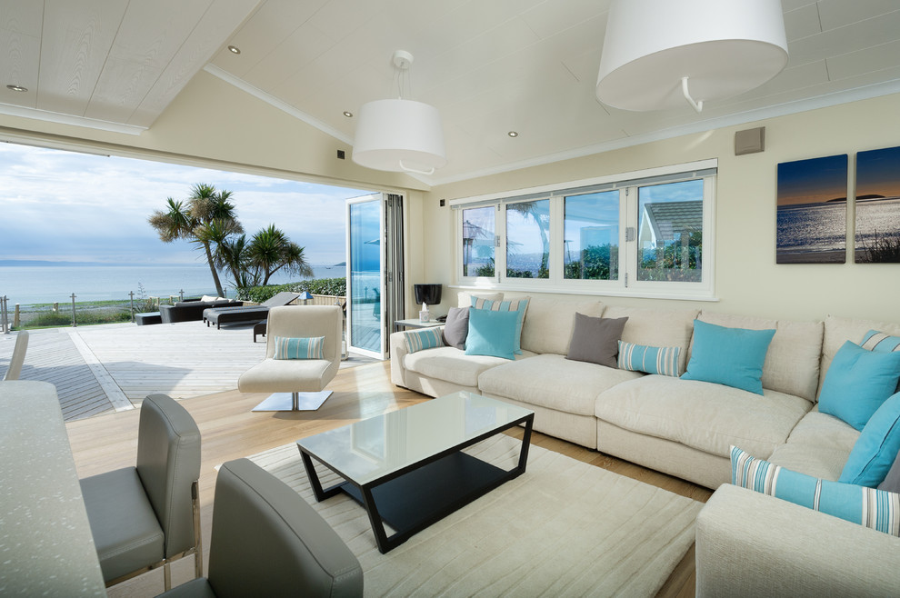 Immagine di un soggiorno stile marinaro aperto con sala formale, pareti gialle, parquet chiaro e pavimento beige