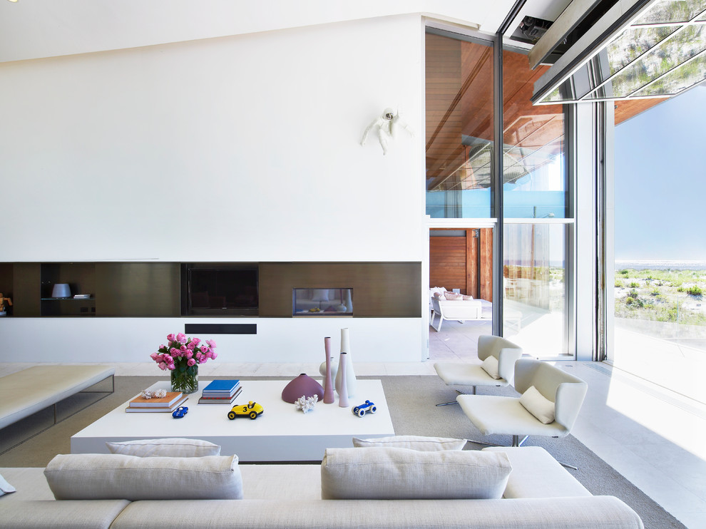 Inredning av ett modernt vardagsrum, med vita väggar, en dubbelsidig öppen spis och en väggmonterad TV