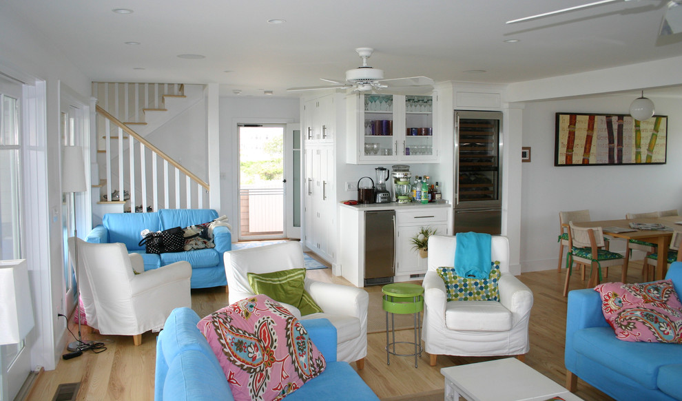 Photo of a large coastal open plan living room in Providence with white walls, light hardwood flooring, no fireplace, a home bar, no tv and brown floors.