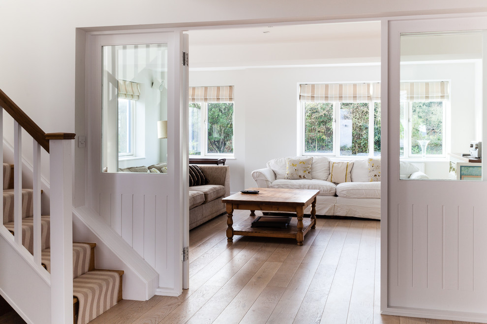 Foto de salón cerrado costero con paredes blancas y suelo de madera en tonos medios