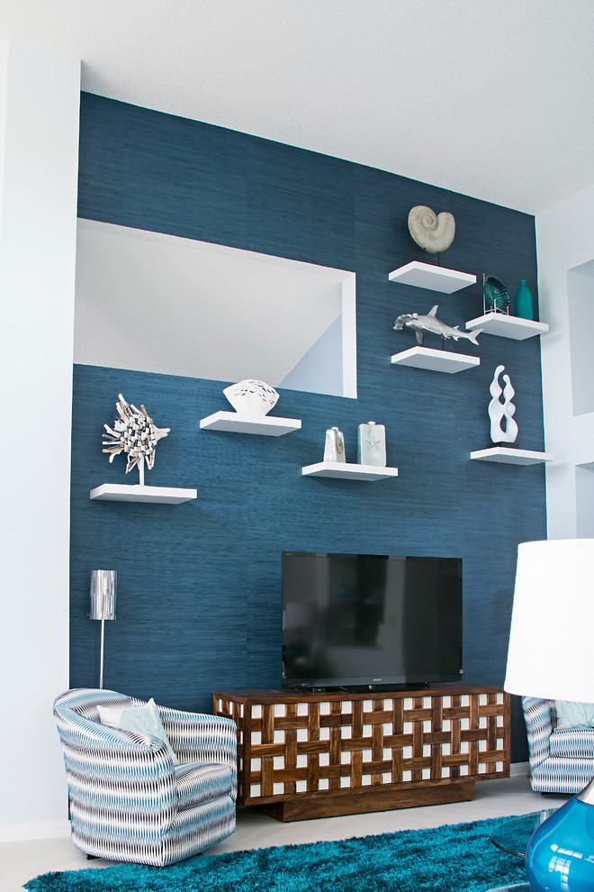 Modelo de salón para visitas abierto marinero grande con paredes azules, suelo de baldosas de porcelana y televisor independiente