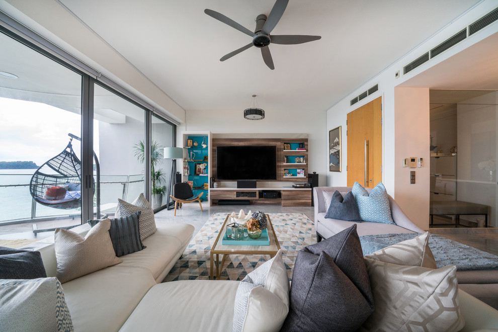 This is an example of a coastal living room in Singapore with white walls, a built-in media unit and grey floors.