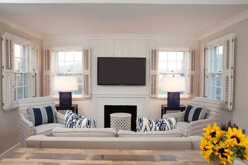 Mid-sized beach style enclosed living room photo in Boston with beige walls, a standard fireplace, a brick fireplace and a wall-mounted tv