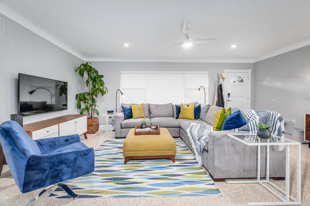 Источник вдохновения для домашнего уюта: гостиная комната в морском стиле с серыми стенами, телевизором на стене и бежевым полом