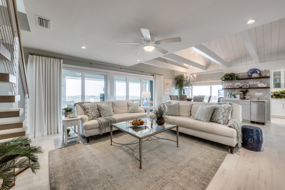 Esempio di un soggiorno stile marinaro aperto con pareti grigie, parquet chiaro e pavimento beige