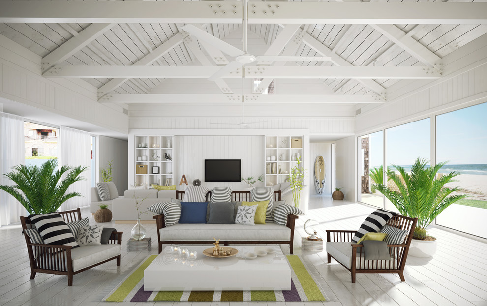 Imagen de salón abierto costero con paredes blancas, suelo de madera pintada y televisor colgado en la pared