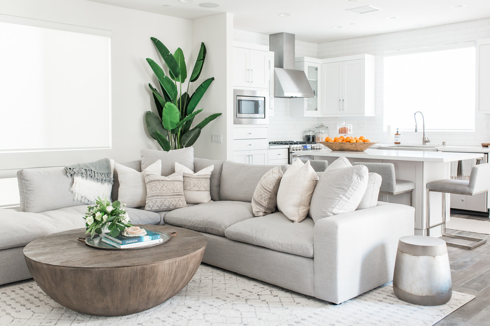Design ideas for a beach style open plan living room in Orange County with white walls and grey floors.