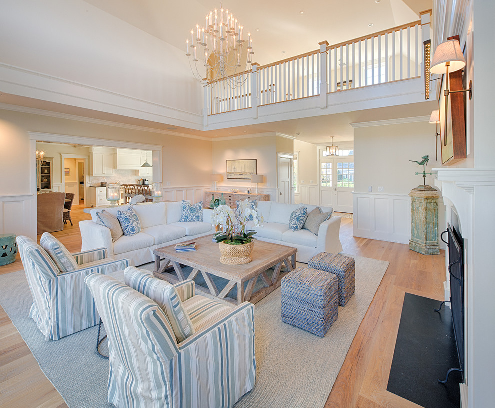Inspiration for a coastal medium tone wood floor living room remodel in Other with beige walls and a standard fireplace