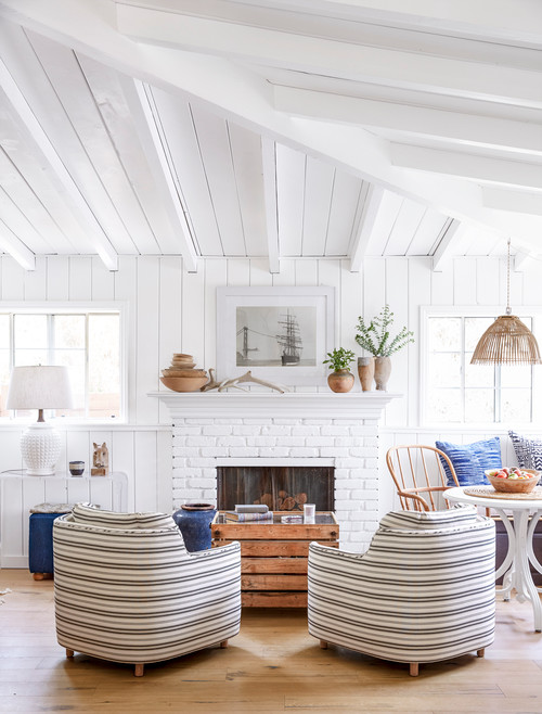 small coastal open concept light wood floor living room remodel in Los Angeles with white walls, a standard fireplace, a brick fireplace and no tv 