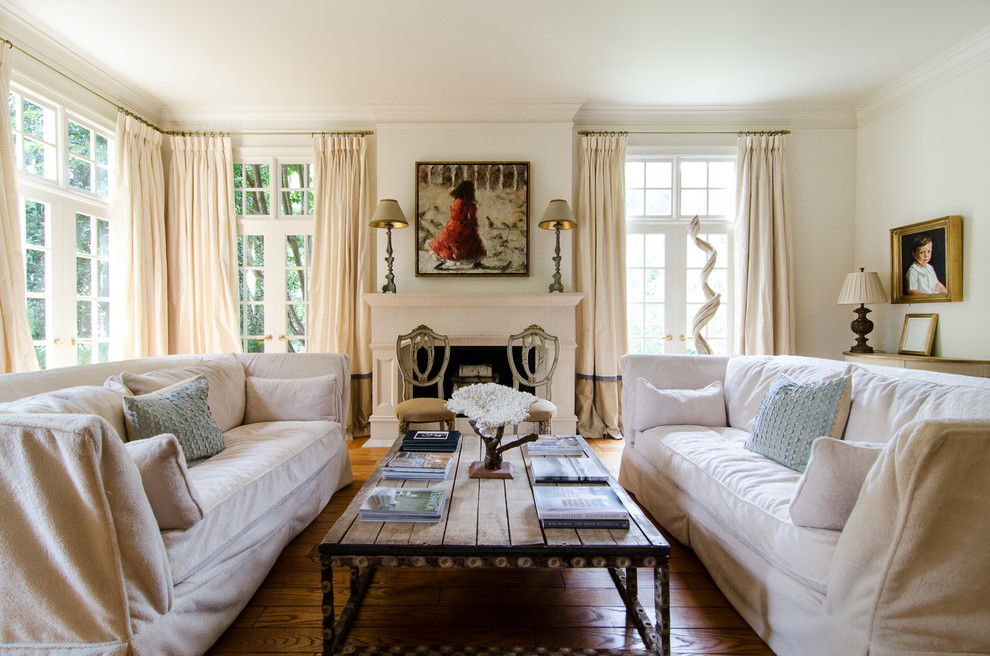 Large beach style enclosed living room in Atlanta with white walls, medium hardwood flooring, a standard fireplace and no tv.