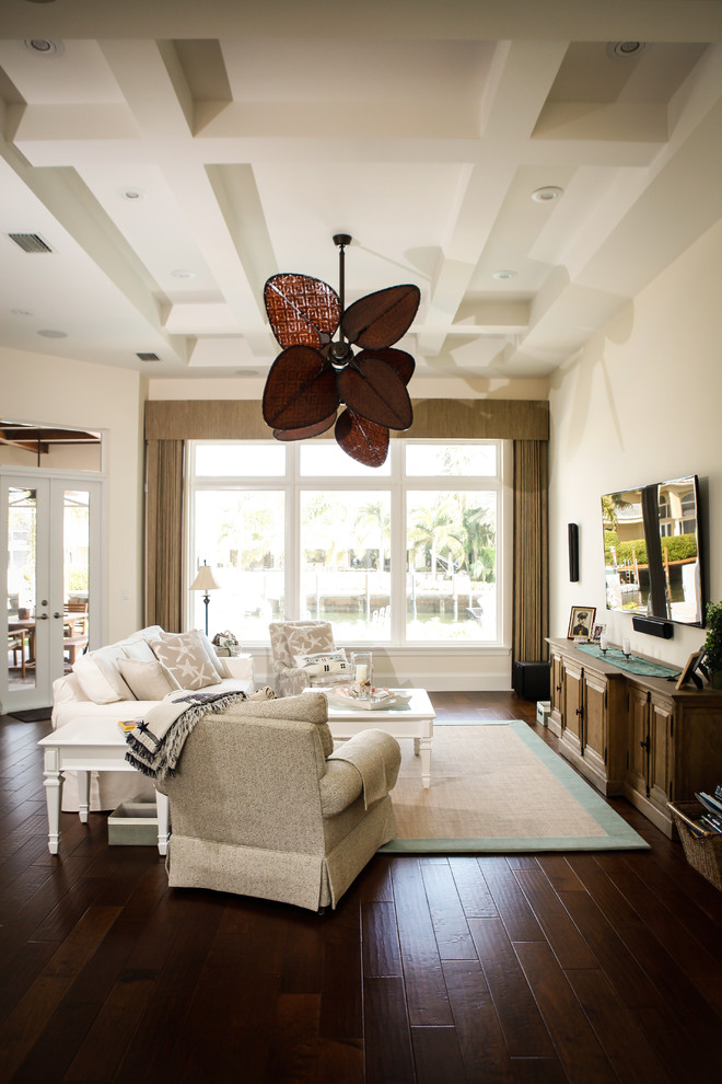 Offenes Maritimes Wohnzimmer mit beiger Wandfarbe, dunklem Holzboden und TV-Wand in Miami