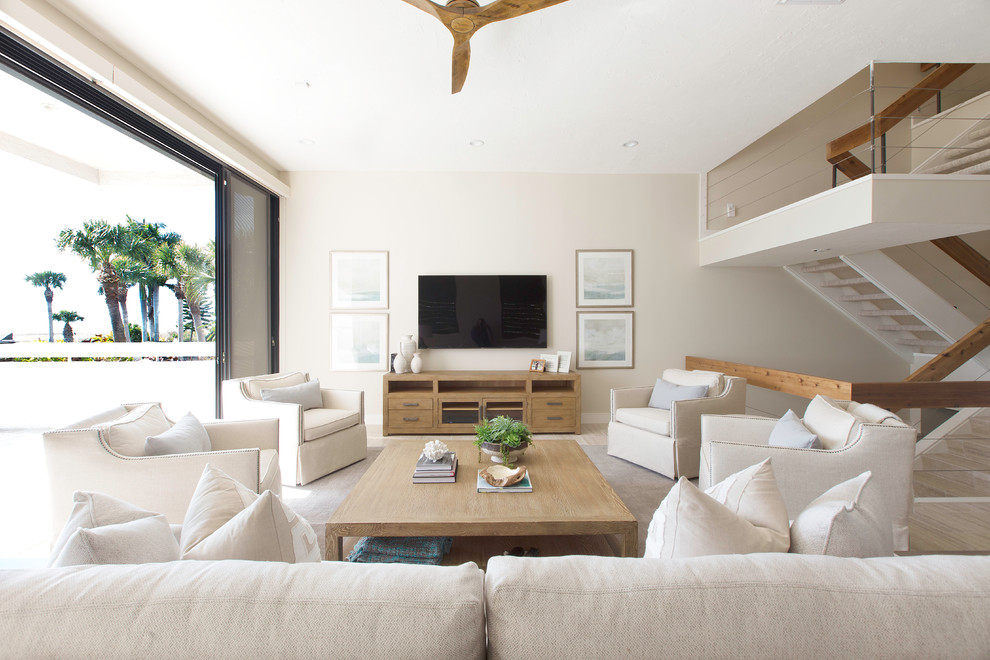 Ejemplo de salón abierto tradicional renovado de tamaño medio con paredes beige, suelo de baldosas de porcelana, televisor colgado en la pared y suelo beige