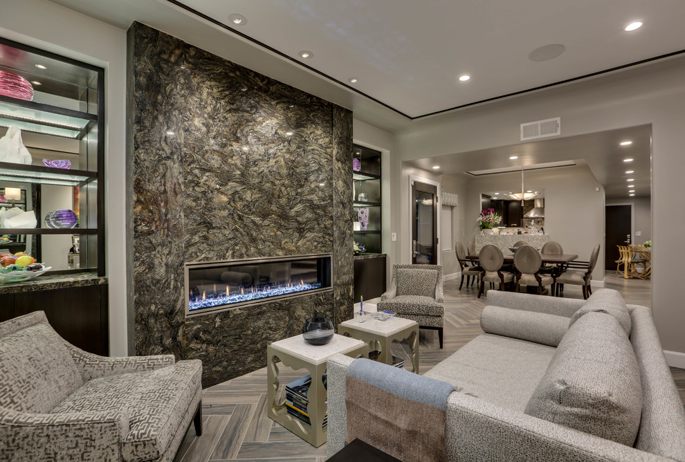 Imagen de salón abierto clásico renovado de tamaño medio sin televisor con paredes grises, suelo de baldosas de porcelana, chimenea lineal y marco de chimenea de piedra