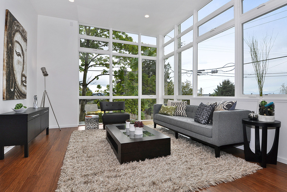 Inspiration pour un salon design avec un mur blanc, un sol en bois brun et une salle de réception.