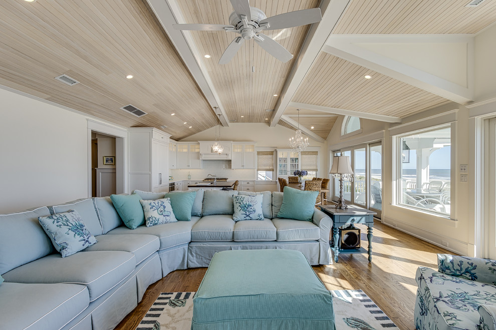 Immagine di un ampio soggiorno stile marino aperto con sala formale, pareti beige, pavimento in legno massello medio e pavimento marrone