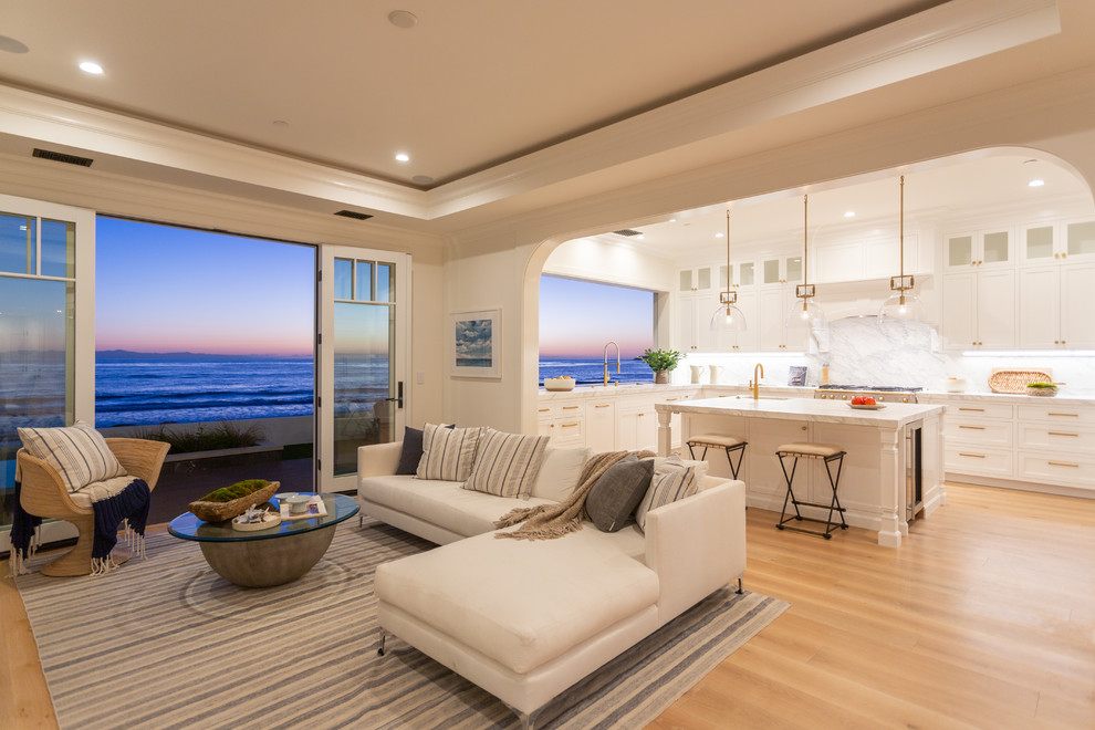 This is an example of a beach style living room in Los Angeles with beige walls, light hardwood flooring and beige floors.
