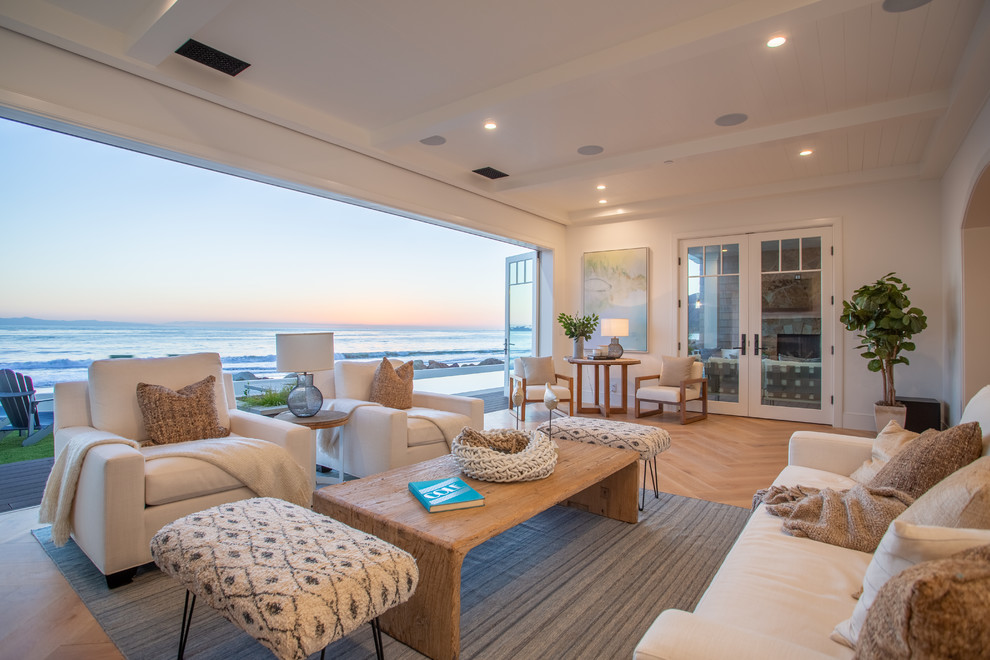 Maritimes Wohnzimmer mit weißer Wandfarbe, braunem Holzboden und braunem Boden in Los Angeles