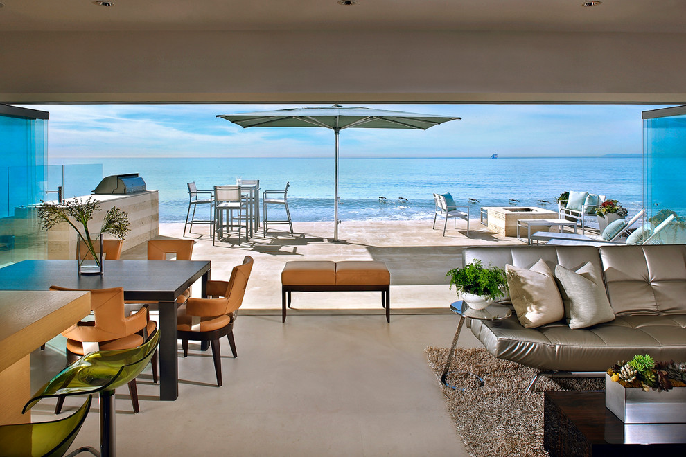 Foto di un grande soggiorno stile marino aperto con pareti beige e pavimento in cemento