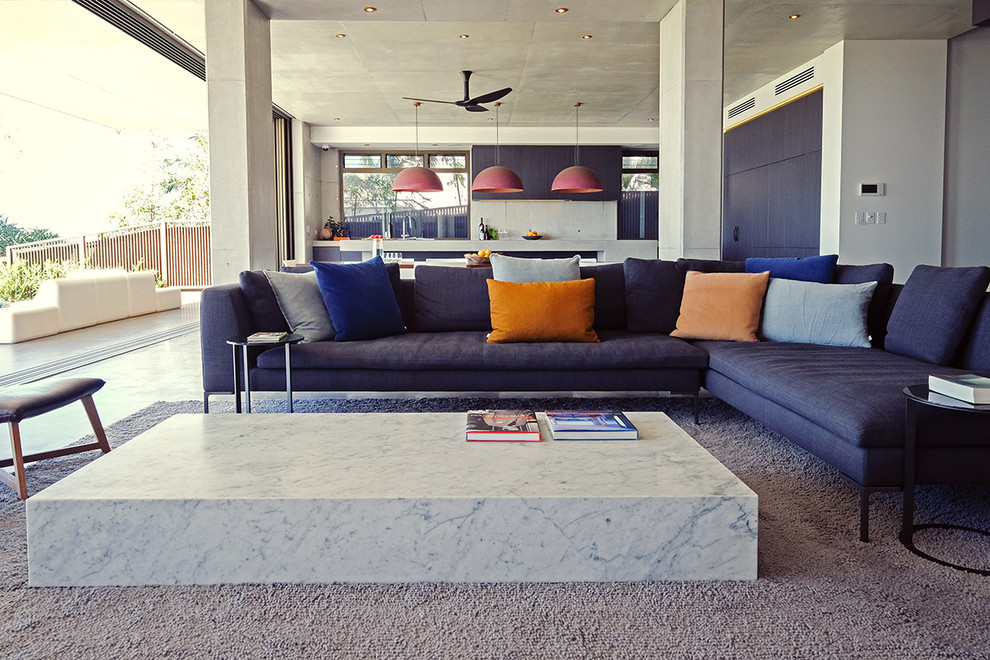 Large contemporary open plan living room in Brisbane with grey walls, concrete flooring, a wall mounted tv and grey floors.