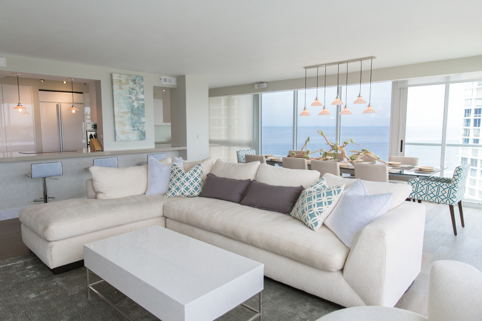 Offenes, Großes Modernes Wohnzimmer ohne Kamin mit hellem Holzboden, weißer Wandfarbe und TV-Wand in San Diego